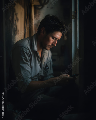 Tired gig worker reviewing today's earnings on mobile phone