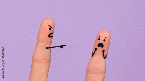 Two Human Fingers with Hand Drawn Angry and Scared Faces Illustrating Bullying Behavior, Concept for Workplace Harassment or Conflict