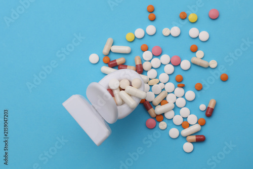Foto Miniature toy toilet and many pills on blue background