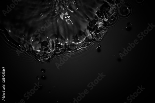 Bild auf Leinwand Black and White Water Splash with Droplets on Dark Background