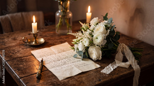 Handwritten love letter and fresh flowers arranged in an intimate romantic setting