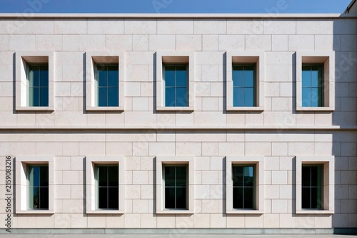 Modern Building Exterior with Symmetrical Windows and Elegant Stone Facade