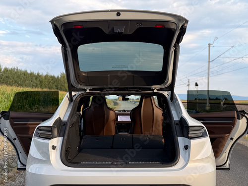 Obraz na płótnie Rear view of a white suv with open trunk and both back doors, showing spacious l
