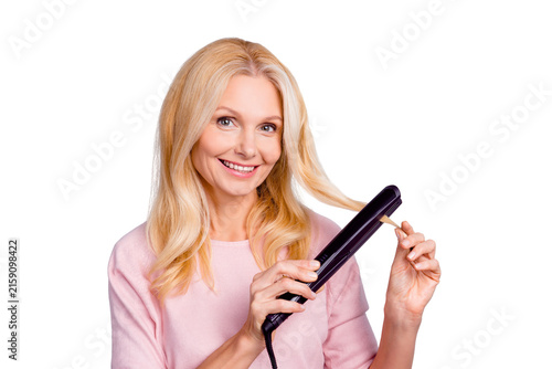 Quadro su tela Portrait of cheerful charming pretty stylish trendy woman using straightener for