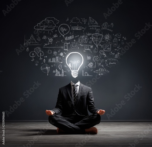 Businessman Meditating with Bright Idea Lightbulb and Business Doodles