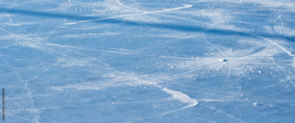 Fototapeta premium Closeup of ice skating rink surface with skate marks