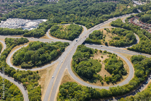 Aerial View of a Cloverleaf Highway Interchange Surrounded by Lush Green Summer Forest