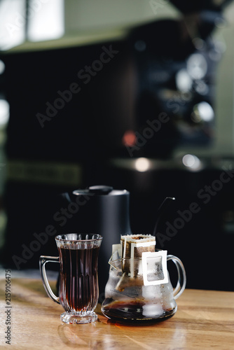 Fotografie Fresh coffee drink, hot water into drip bag on roasting shop background