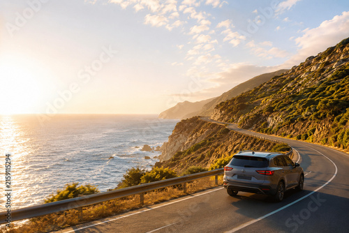 Coastal Road Trip at Sunset: A car travels along a winding road by the sea, with the sun setting over the ocean, casting a warm, golden light on the landscape and the waves crashing against the shore.