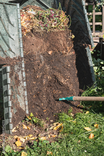 Close-up of garden fork digging into rich compost pile