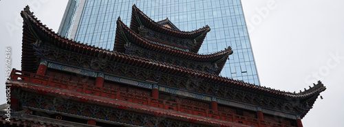 Foto Golden tiered temple roofs against glass skyscrapers, China