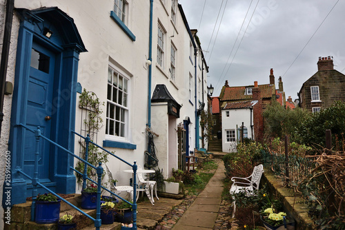 Historic fishermen's cottages in Robin Hood's Bay, North Yorkshire; narrow cobblestone alleyway and traditional architecture in charming seaside fishing village, North York Moors, England, UK