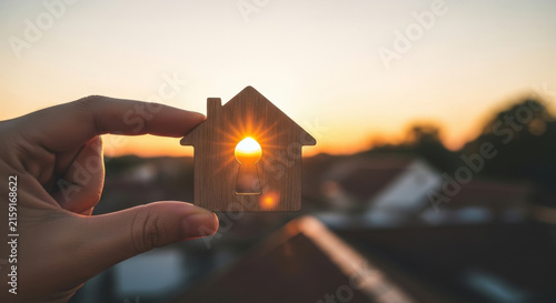 Hand Holding Small Wooden House Keyhole Shape against Sunset Sky Real Estate Dream Home Ownership Target Concept Building Wealth New Beginning