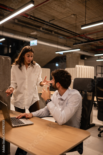 Картината върху платно Coworkers having an argument in modern office at night