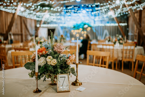 Foto Elegant table setting with floral centerpiece and candles in a rustic venue deco