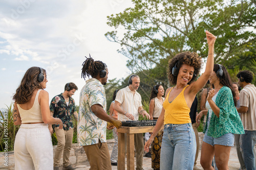 Diverse adults enjoying a silent disco outdoors with wireless headphones and joyful movement