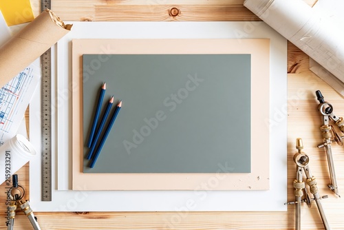 Architects worktable with a sage green drafting sheet and copy space, featuring professional tools and rolled blueprints for design service marketing