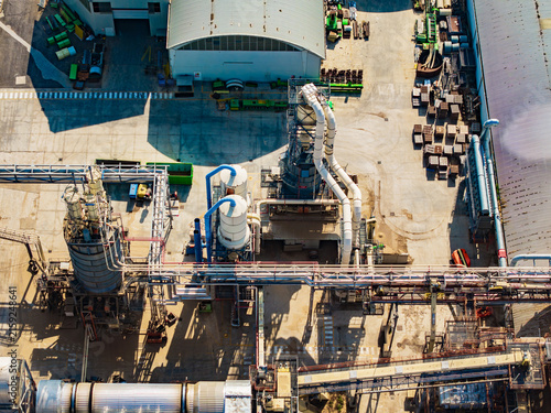 Aerial view of a modern food factory featuring industrial processing equipment, large storage tanks, complex piping systems, and a concrete yard in Pomposa, Emilia-Romagna, Italy.