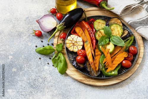 Grilled vegetables: red and yellow paprika, garlic, zucchini, eggplants, carrots on a stone tabletop. Summer homemade recipe. Copy space.