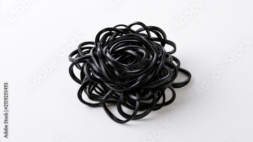 A tangle of black elastic rubber bands isolated on white background. This abstract image represents complexity, chaotic systems, or organizational challenges.