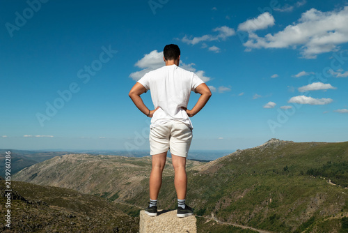 Quadro su tela Jovem turista no topo de um rochedo a contemplar a vista panorâmica sobre as mon