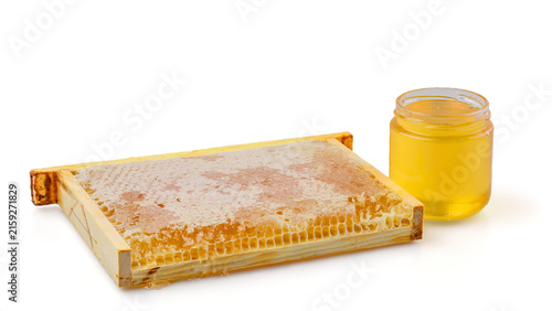Frame with wax-sealed honeycombs and jar with linden honey isolated on white background.