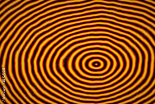 Abstract circular ripples pattern with vibrant orange and black hues for dynamic graphic backgrounds