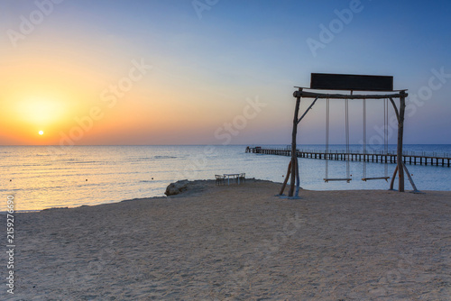 Wooden swing over the Red Sea in Marsa Alam at sunrise, Egypt