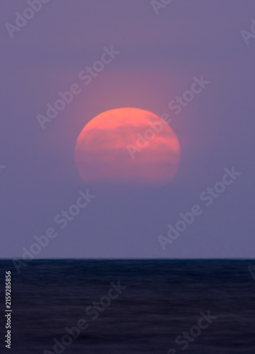 Full buck moom rising over ocean, galveston, Texas, USA.