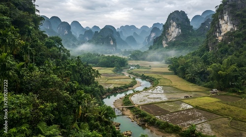 Dramatic landscape of karst mountains and a winding river through lush green rice paddies