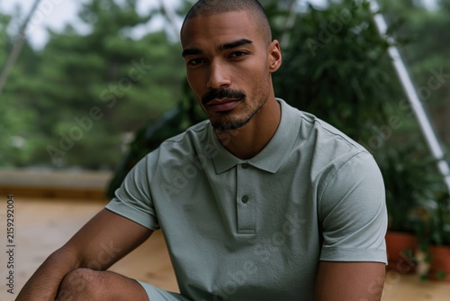 Seated male polo portrait in a wooden greenhouse with plants for lifestyle banner and background design