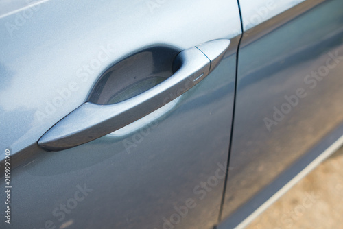 Bild auf Leinwand Close-up image of a car door handle on a blue vehicle, highlighting the smooth s