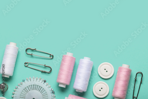 Quadro su tela Composition with thread spools, ball pins and buttons on mint background, closeu