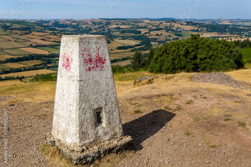 Canvastavla Weathered triangulation pillar on hilltop summit, panoramic view over patchwork