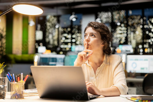 Obraz na płótnie Focused female employee reflecting on a business strategy puzzle