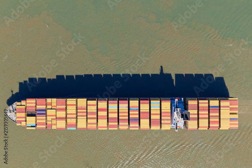 Large Container Ship Traveling Across Calm River Waters During Bright Daylight