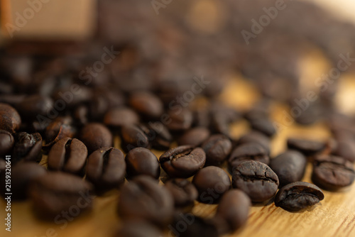 Roasted coffee beans scattered on a wooden surface