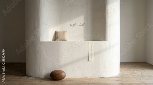 Minimalist interior design featuring a textured white curved plaster walls with organic wooden sculpture on a timber floor under soft natural sunlight, perfect for zen and serene home decor