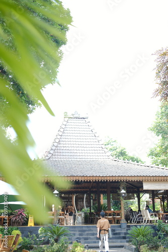 Traditional Javanese Joglo pavilion architecture in a lush tropical garden setting