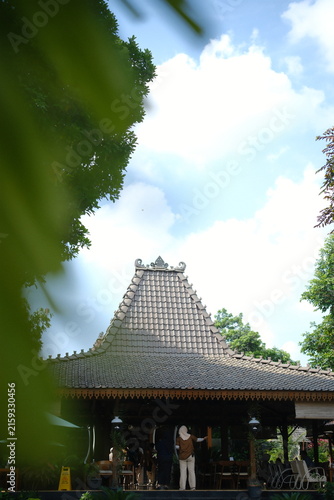 Traditional Javanese Joglo house architecture with wooden roof structure in tropical garden