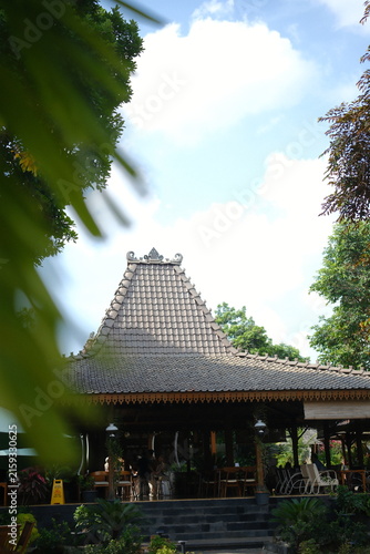 Traditional Javanese Joglo house architecture with wooden roof structure in tropical garden