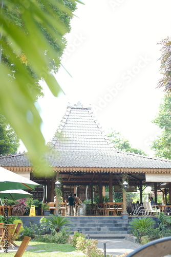 Traditional Javanese Joglo house architecture in a lush tropical garden setting