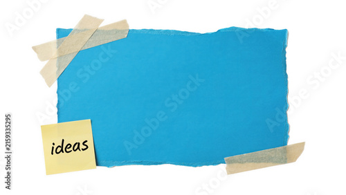 Foto Blue paper with sticky note 'ideas' attached with tape isolated on white