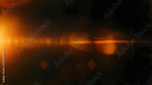 Abstract dark background with intense golden orange light flare and lens streaks background abstract brightness illumination backdrop