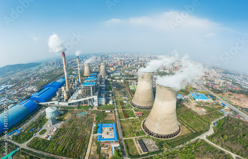 Konstfotografi Aerial shot of a large thermal power plant with cooling towers and chimneys, adjacent to an urban area under clear sky