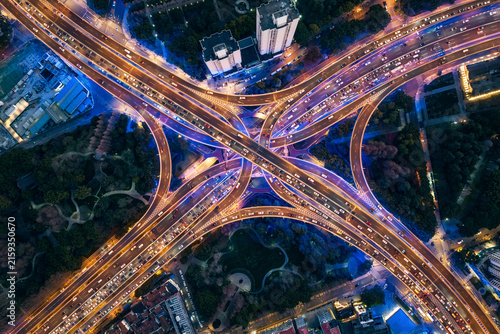 Photography A top-down aerial shot of a complex multi-level urban road interchange at night, showing busy traffic flow