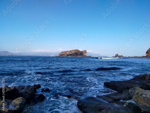 Scenic Seascape with Rocky Shore and Distant Island