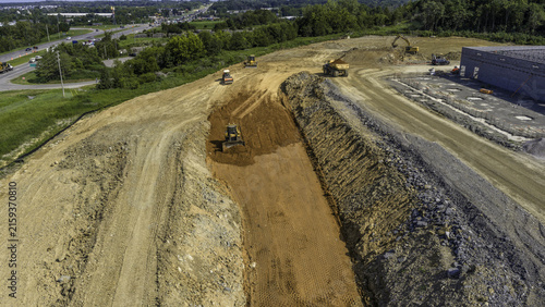 Aerial view of a Caterpillar bulldozer, hydraulic excavator, and a dump truck moving dirt at a large construction site, Mt. Juliet, Tennessee, United States.