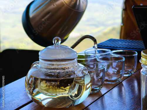 Pouring Hot Water Into Glass Teapot With Loose Tea Leaves