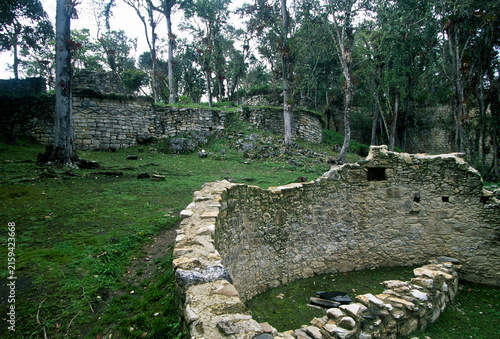 A wide angle landscape photograph showing the extensive pre-Columbian stone ruins of Kuelap Chachapoya site in Northern Peru